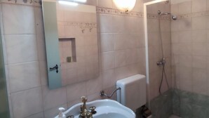 A bathroom with a sink, mirror, shower, and toilet. - RICHARD COMFORT - STUDIO APARTMENT WITH PATIO (TORRE SAN GIOVANNI)