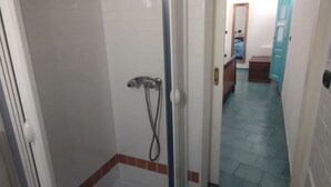 Une salle de bain avec une douche, des murs carrelés et un sol carrelé.