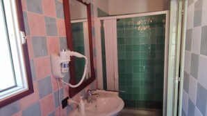 Une salle de bain avec un lavabo, un miroir et une douche.