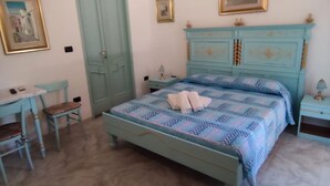 Une chambre à coucher comprenant un lit, une table de chevet, une chaise, une table et une armoire.
