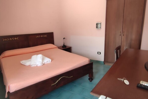 A bedroom with a bed, bedside table, and a wardrobe.