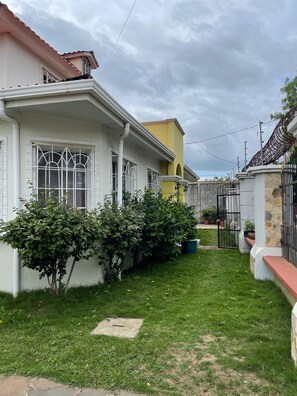 A residential property with a well-maintained lawn, a gated entrance, and a clear sky. - Tropical Oasis in Managua (Nindiri)