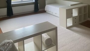 A room with a large window, a white bed, a white desk, and a radiator. - Ferienwohnung am Lindenplatz - Wohnung Weitblick (Baumgarten)