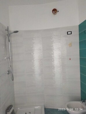 Ein Badezimmer mit Dusche, Toilette und Waschbecken.