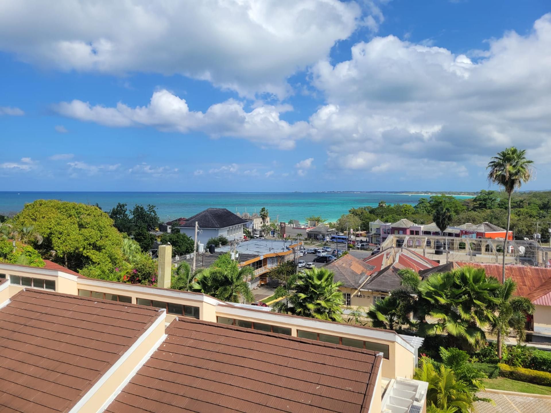 A coastal town with buildings, a clear sky, and a view of the ocean.