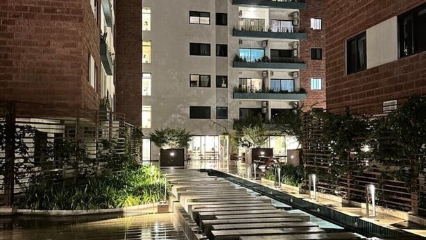 Un edificio moderno con diversi piani, balconi e un cortile centrale con fontana.