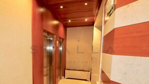 A narrow hallway with wooden paneling on the walls and a tiled floor. - LUXURY LISBOA APARTMENT T2 (Lisbon)