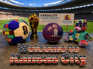 A welcome sign, a trophy, a soccer ball, and a stuffed toy with a sign in a stadium.