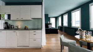 A modern kitchen with white cabinets, a dining area with a table and chairs, and large windows offering a view.