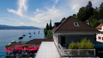 A waterfront restaurant with outdoor seating and a view of boats on the water.