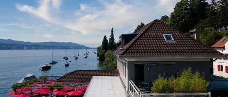 Un restaurant situé au bord de l’eau, avec une terrasse et une vue sur les bateaux qui naviguent.