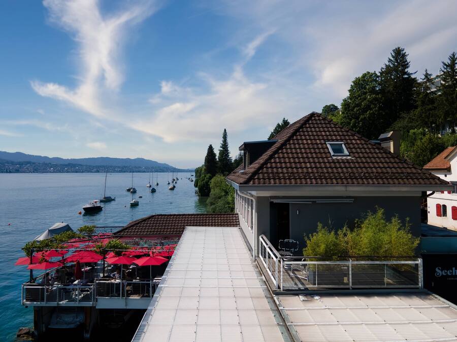 Een restaurant aan het water met terras en uitzicht op boten.