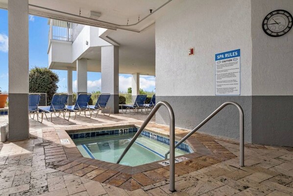 Un espace piscine agrémenté d’un panneau indiquant une profondeur de 3 pieds, de chaises longues et d’une horloge murale.
