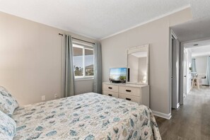 A bedroom with a bed, a television, and a dresser. - Pools - Near Main St - Beach Steps Away - Waipani (North Myrtle Beach)