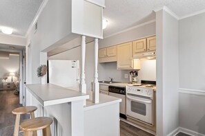 A kitchen with a central island, white cabinetry, a stove, and a dishwasher. - Pools - Near Main St - Beach Steps Away - Waipani (North Myrtle Beach)