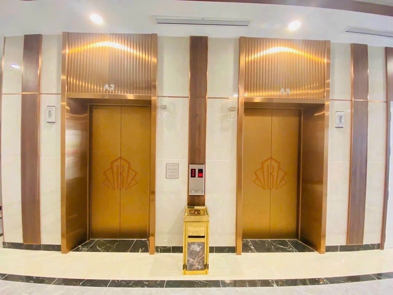 Dois elevadores com acabamento metálico e um painel de controle central.