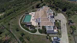 Ein großes, modernes Haus mit Pool, mehreren Zimmern und einer Auffahrt.