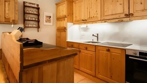 Une cuisine avec des meubles de rangement en bois, un évier et une cuisinière.