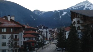 A town with buildings and a mountain in the background. - Stayinn Granat - 2 Bedroom Apartment - Next to Gondola Lift, Perfect for 4pers (Bansko)
