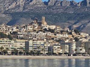 A coastal town with a prominent church and a rocky mountain backdrop. - HOSTAL LUXURY NIT I DIA (Altea)