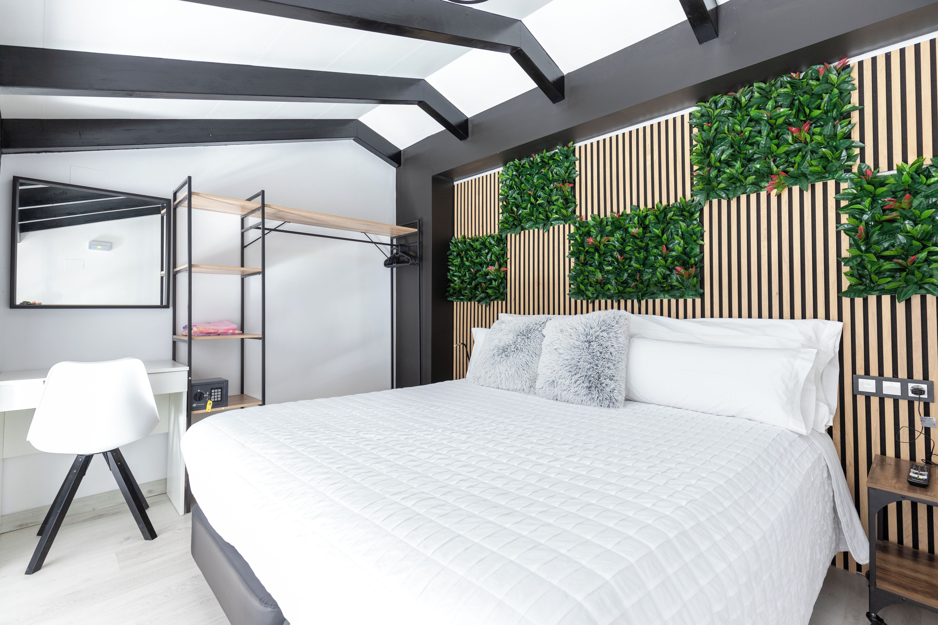 Un dormitorio moderno con cama, escritorio y estantería.