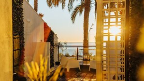A patio area with a view of the sea, white chairs, and a table set for dining. - HOSTAL LUXURY NIT I DIA (Altea)