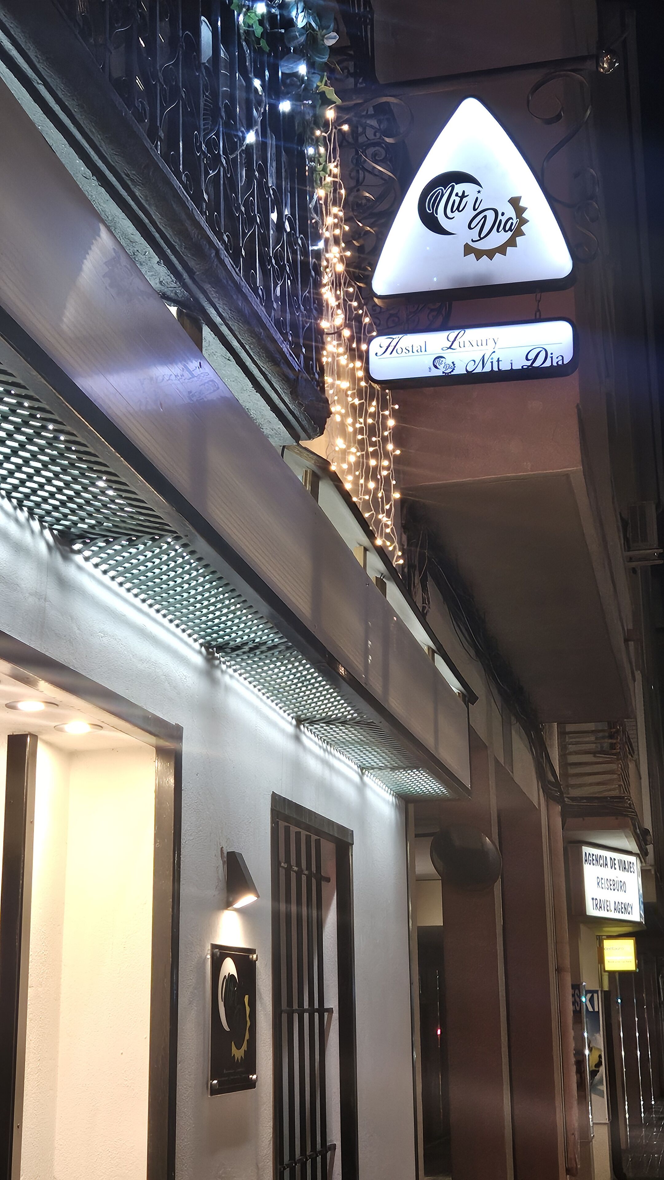 L’entrée d’un hôtel avec une enseigne indiquant « Hostal Luxury » et « Niti Mit Dia ».