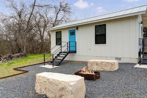 Un bâtiment avec une porte bleue, un foyer et un escalier menant à une terrasse.