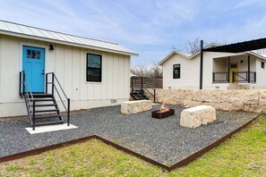 A building with a blue door, a staircase, a fire pit, and a stone wall. - Casita Fulton - Fire Pit & Close to Main St (Fredericksburg)