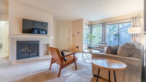 Ein Wohnzimmer mit Kamin, einer Couch, einem Couchtisch und einem Fernseher.