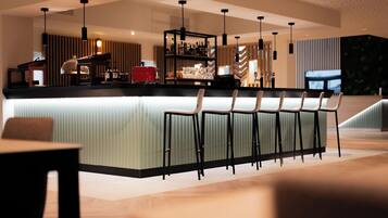 A modern bar area with a long counter and multiple bar stools.