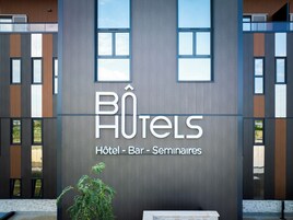 Un edificio moderno con un cartel que dice "BÔTELS HOTEL - BAR - Seminarios".