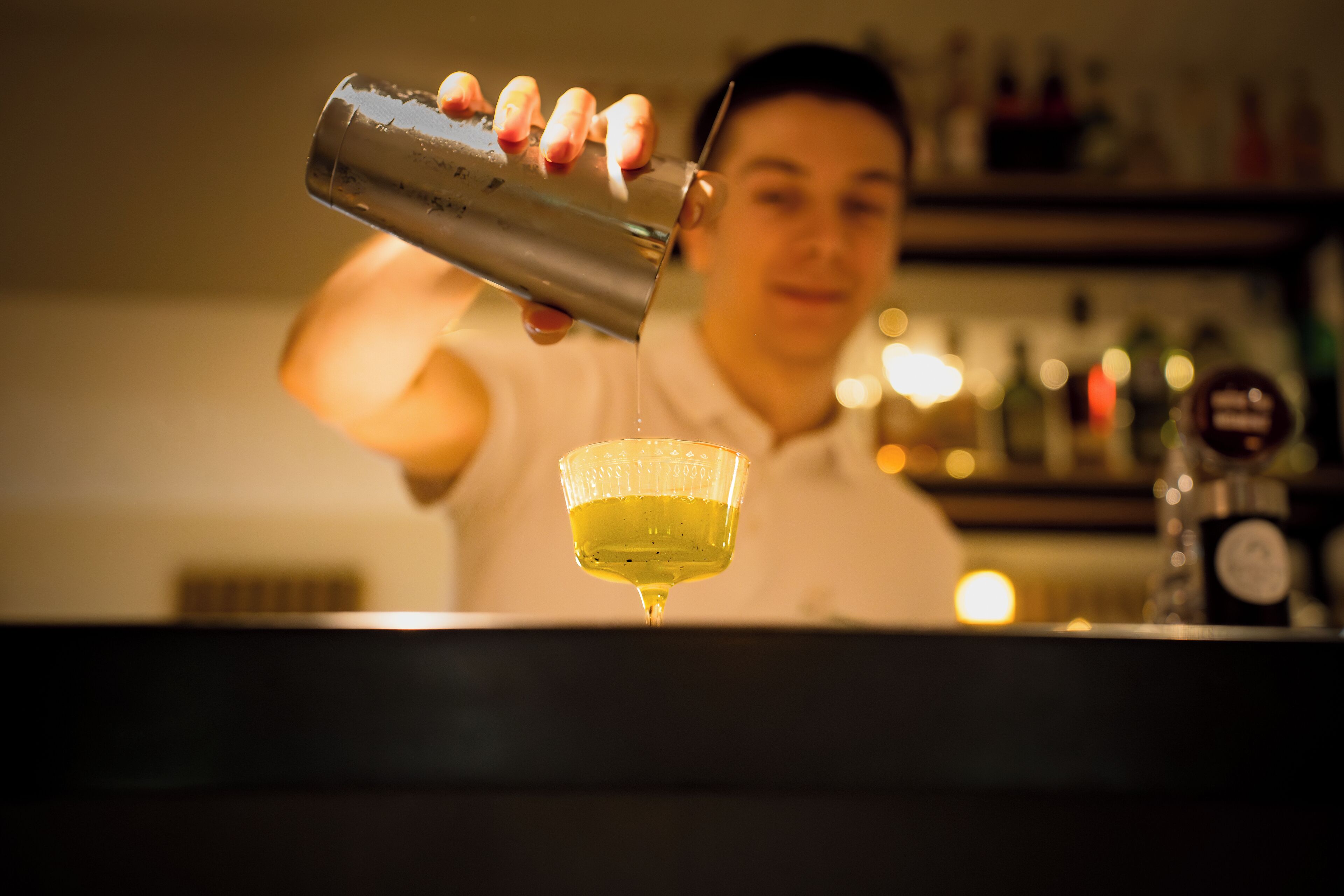 Un barman verse une boisson dans un verre.