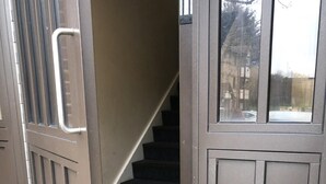 A brown exterior door with a metal handle and a glass panel.
