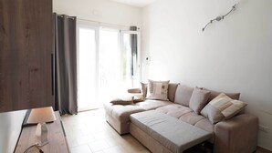 A modern living room with a sectional sofa, a wooden sideboard, and a wall-mounted light fixture. - 3724 All' Ombra Degli Ulivi by Barbarhouse (Latiano)