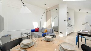 Un salon moderne et bien éclairé, avec un coin repas aménagé pour prendre un repas.