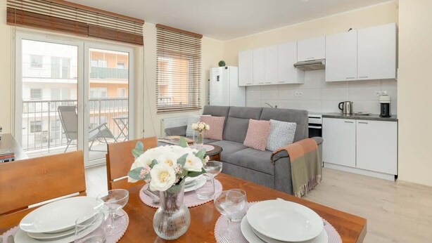 A modern apartment with a dining area, kitchen, and balcony. - Stylish Apartment with Balcony | Guaranteed Parking (Poznan)
