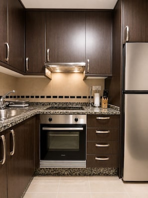 Una cocina moderna con armarios de madera oscura, electrodomésticos de acero inoxidable y una encimera de granito.
