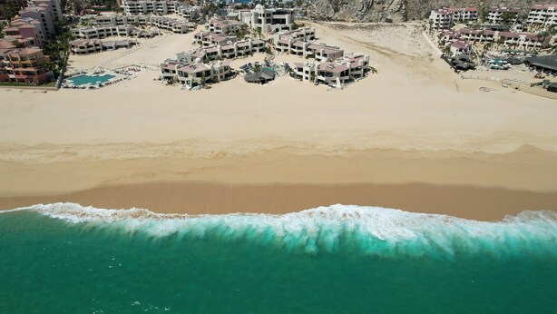 A coastal resort with multiple buildings, a beachfront, and a swimming pool. - Oceanfront Condo w/ Private Deck & Stunning Views - Unit 150 Casa Kelly (Cabo San Lucas)