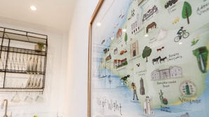 A framed map of Isle of Wight with labeled landmarks and a kitchen area with a sink and dish rack. - Creek Lodge (Ryde)