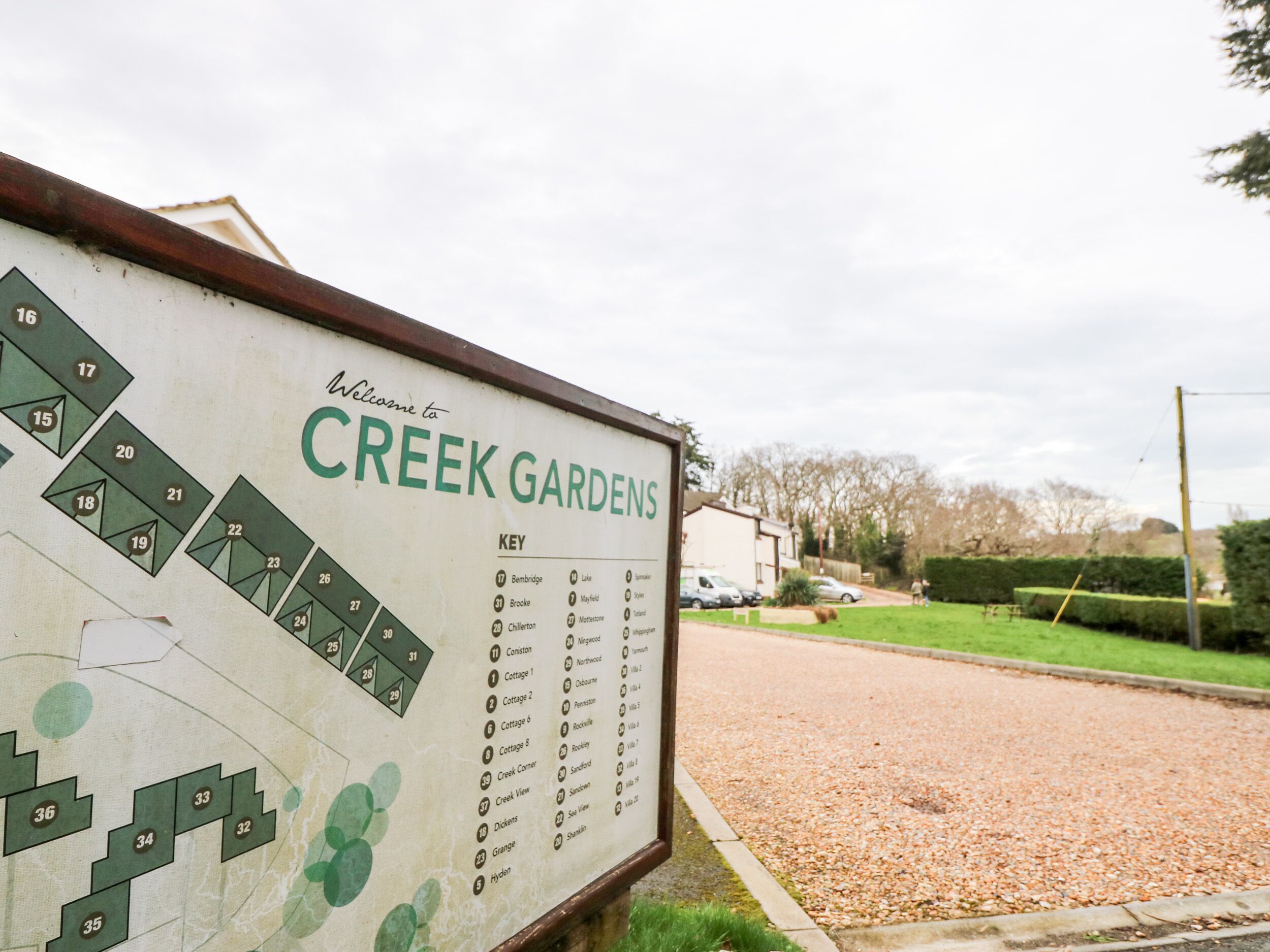 A sign for Creek Gardens with a map and key listing garden names and numbers.