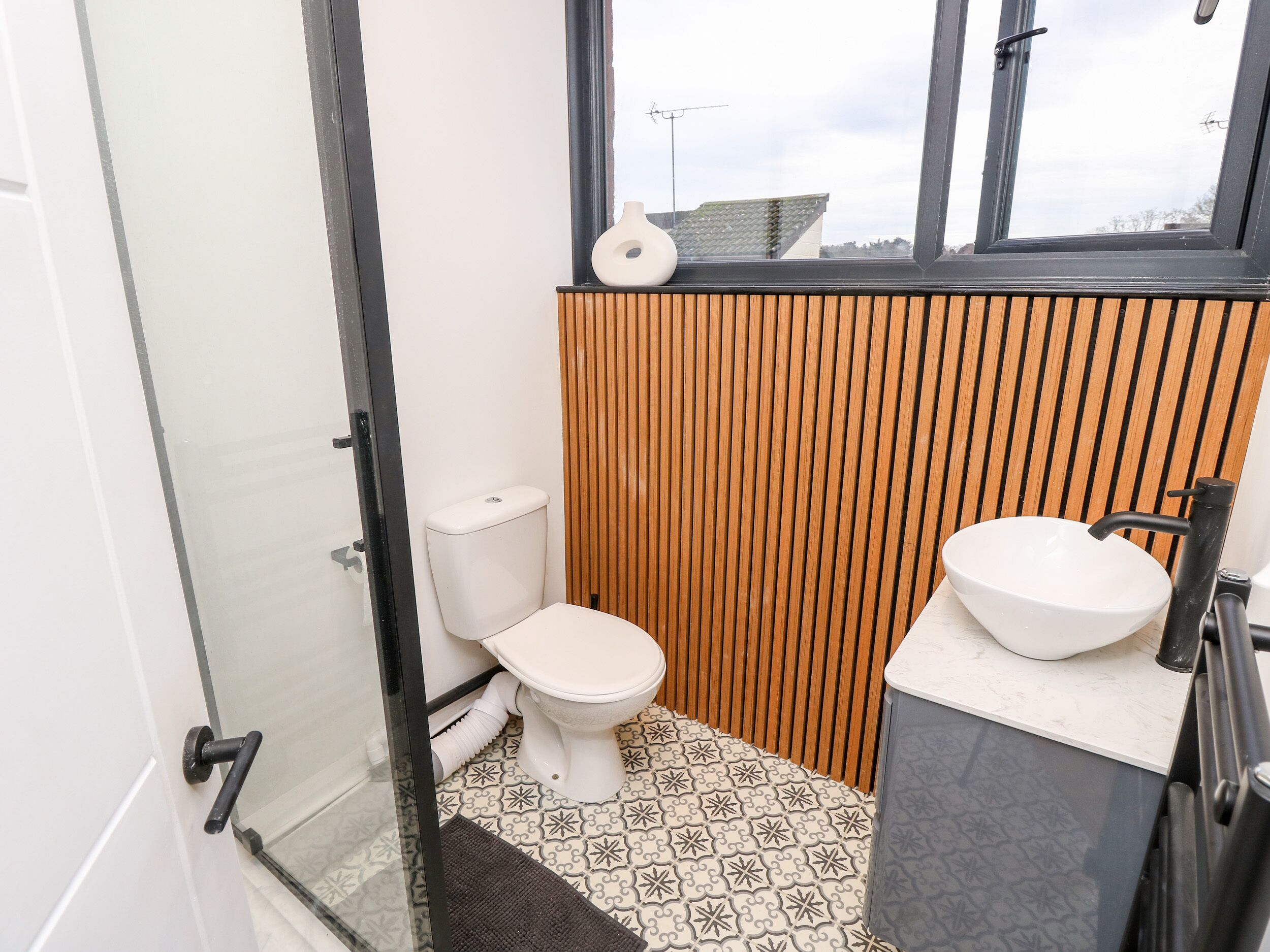 Un baño pequeño con inodoro, lavabo y zona de ducha.