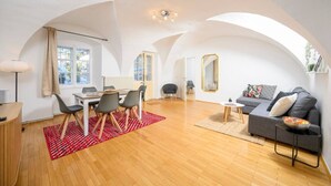 A spacious living area with a dining table, sofa, and a large mirror. - City Center Mödling top 1 (Mödling)