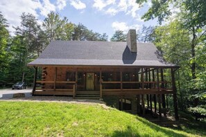 A log cabin with a porch, a chimney, and a deck. - Honey Goat Hill, Sleeps 10, Centrally Located with Wooded Views (Logan)