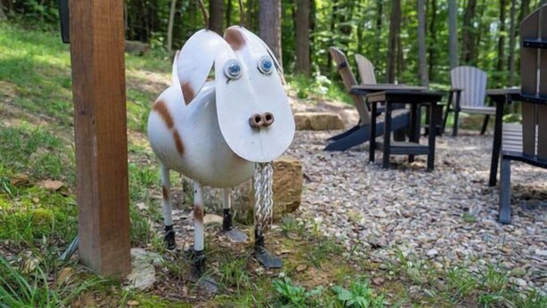 A rustic outdoor seating area with a wooden post, a table, and chairs. - Honey Goat Hill, Sleeps 10, Centrally Located with Wooded Views (Logan)