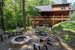 A wooden cabin with a deck, outdoor seating, and a fire pit. - Honey Goat Hill, Sleeps 10, Centrally Located with Wooded Views (Logan)