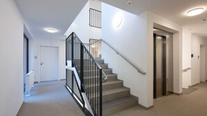 A modern interior with a staircase, a door labeled '5', and an elevator.