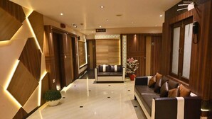 A modern lobby with a sofa and a potted plant. - HOTEL ROYAL COTTAGE (Kanpur)