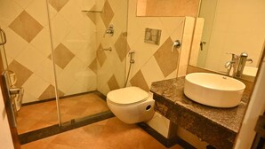 A bathroom with a toilet, a sink, and a shower. - HOTEL ROYAL COTTAGE (Kanpur)