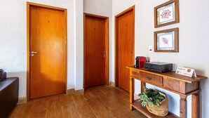 Un pasillo con puertas de madera, un escritorio con una impresora y cuadros en la pared.